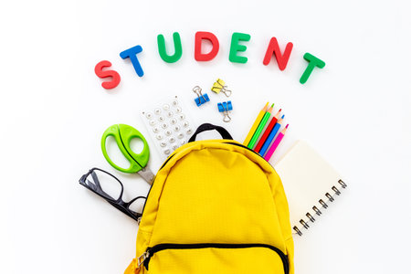 Students supplies in yellow school backpack. Back to school concept
