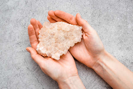 Natural crystal mineral stone in hands. Crystal texture closeup