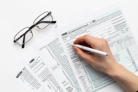Hands filling US tax form. Culculating and payment of taxes concept