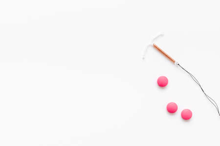 Contraception concept. T-shaped intrauterine contraceptive with medicine pillsの写真素材
