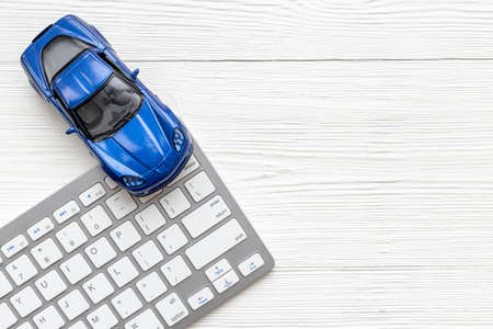 Car for sale concept. Toy car near computer keyboardの写真素材