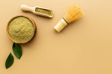 Green matcha powder in bowl with bamboo whiskの写真素材