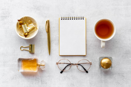 Home work place table with golden colored office supplies. Overhead view