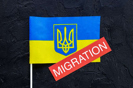 Word migration on Ukrainian flag. Ukrainian immigration conceptの写真素材