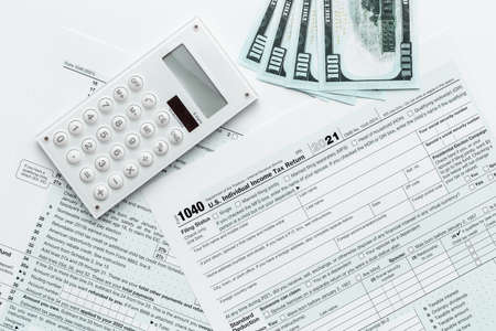 Annual tax form under US law with money cash. Tax payment seasonの写真素材