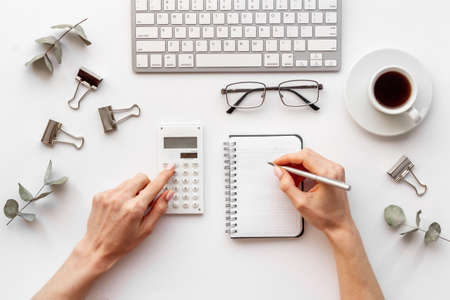Female hands working on office table with silver colored supplies