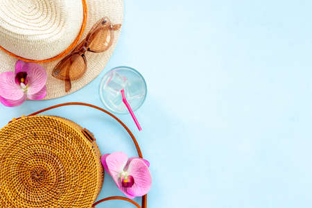 Flatlay of beach accessories with straw hat and rattan bag. Summer beach backgroundの写真素材
