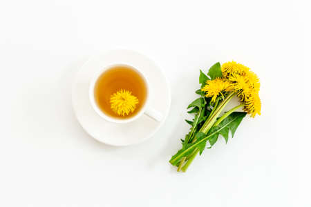 Cup of healing herbal tea with yellow dandelions flowersの写真素材