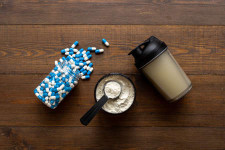 Fitness and gym diet. Whey protein in jar and sport pillsの写真素材