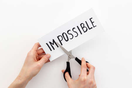 Hands changing word impossible to possible with scissors. Selfmade conceptの写真素材