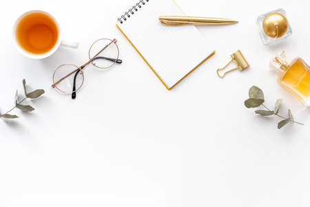 Home work place table with golden colored office supplies. Overhead view