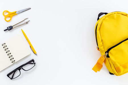 Yellow school backpack with colorful school stationeryの写真素材