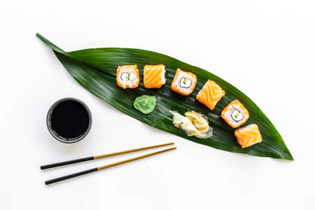 Sushi roll set with chopsticks on green Bamboo leave, top view