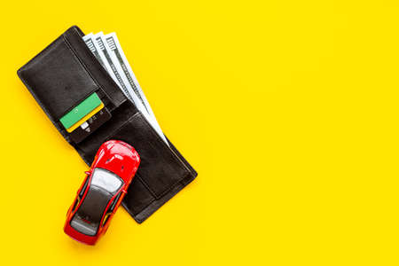 Toy car with wallet and money. Purchase a car concept