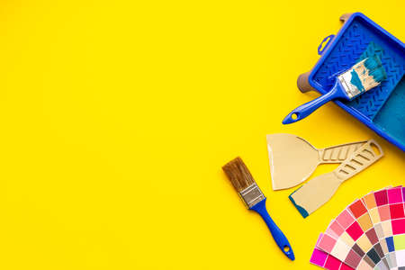 House renovation and painting background with construction helmet and brushes