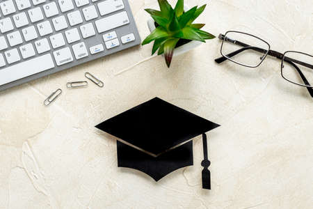 Graduation hat on students table. Masters or Bachelors degree concept