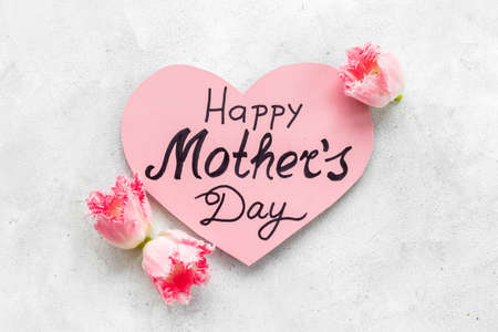 Layout of Happy Mothers day greeting card and pink flowers, top view