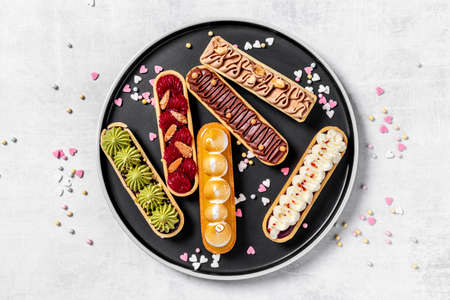 Eclairs with pistachio raspberries and chocolate cream topping