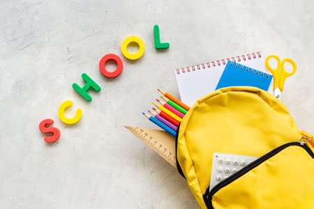 School backpack with school items and students equipment, top view