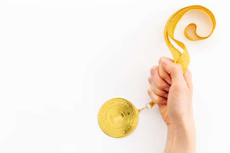 Hand holding up gold medal first place. Winner conceptの写真素材