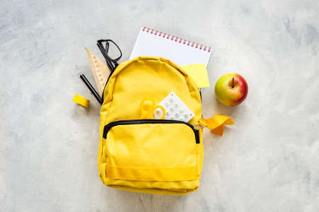 Yellow school backpack with colorful school stationeryの写真素材