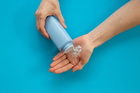 Applying white talcum powder on hand. Skin care cosmetic