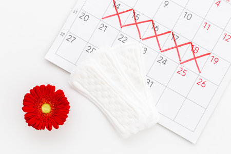 Menstruation period concept with calendar and white pad