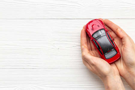 Toy car in hands, top view. Car insurance or driving safety conceptの写真素材