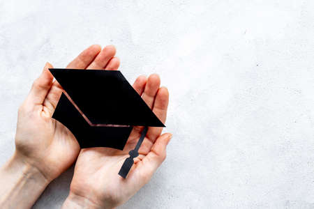 Students hands with graduation hat or academic cap paper cutの写真素材