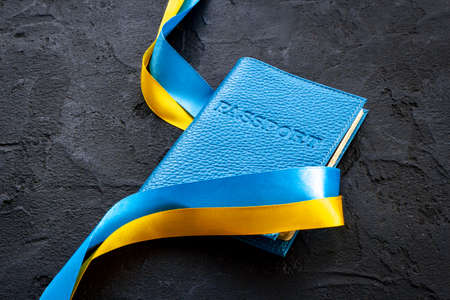 Ukrainian immigration concept - yellow and blue ribbon on passportの写真素材
