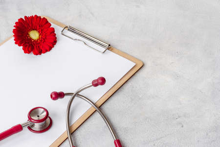 Women health. Doctor gynecologist clipboard with red flower and stethoscopeの写真素材
