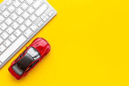 Car rental service concept. Toy car near computer keyboardの写真素材
