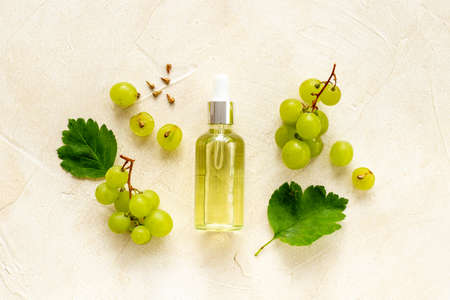 Bottle of grape seed essential oil with grapes. Eco cosmetic productの写真素材