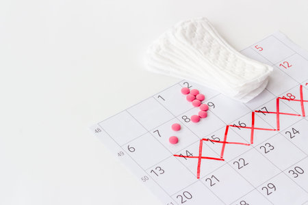 Menstruation period concept with calendar and white pad