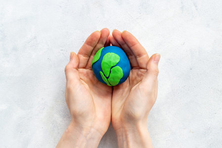 Plasticine world - planet Earth in hands. Eco care concept