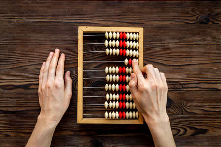 Calculation concept with hands and accounting wooden abacusの写真素材