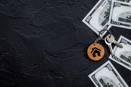 Saving money concept with house shaped keychain and money cashの写真素材