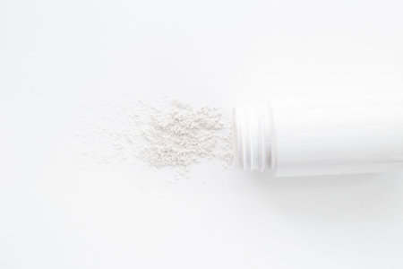 Talcum powder in container. Spilled white powder