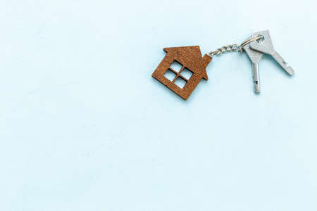 Sale or rent real estate concept. house shaped key chain and keysの写真素材