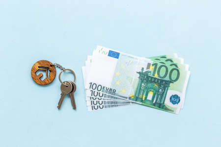 Saving money concept with house shaped key chain and money cashの写真素材