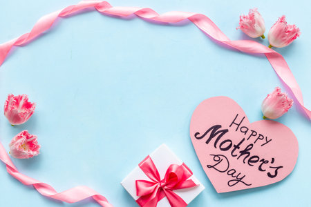 Gift box with pink ribbon over Happy Mothers day greeting card