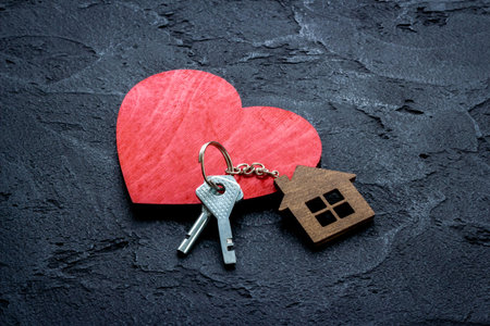 Sale or rent real estate concept. house shaped key chain and keys