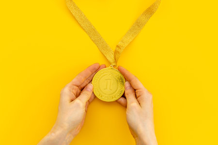 Hand holding up gold medal first place. Winner conceptの写真素材