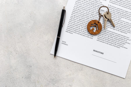 Signing a house purchase agreement with house shaped keychain