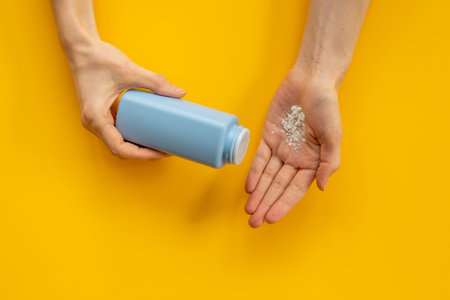 Woman applying baby talcum powder on hand. Skin care cosmeticの写真素材