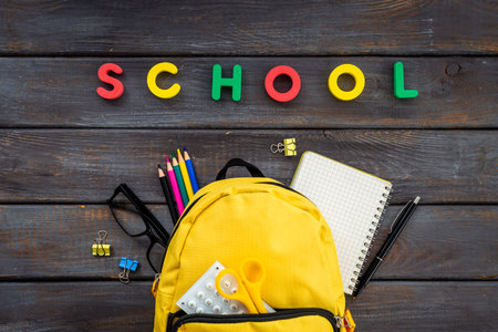 School backpack with school items and students equipment, top view