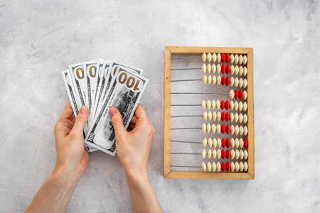 Saving money concept - accounting wooden abacus in handsの写真素材