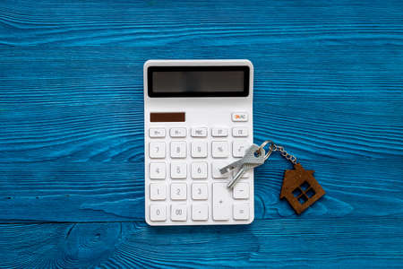 Saving money for buy house concept. House shaped key chain with calculatorの写真素材