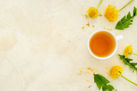 Cup of healing herbal tea with yellow dandelions blossoms and leavesの写真素材