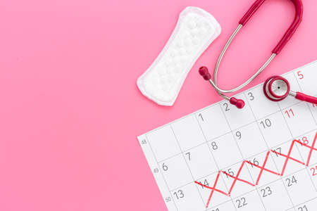 Stethoscope and calendar with red days of menstruation period. Women healthの写真素材